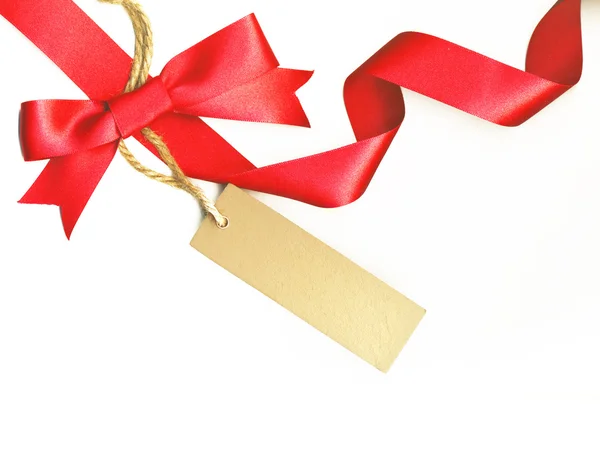 Beautiful ribbon with red bow and a label isolated on white background — Stock Photo, Image
