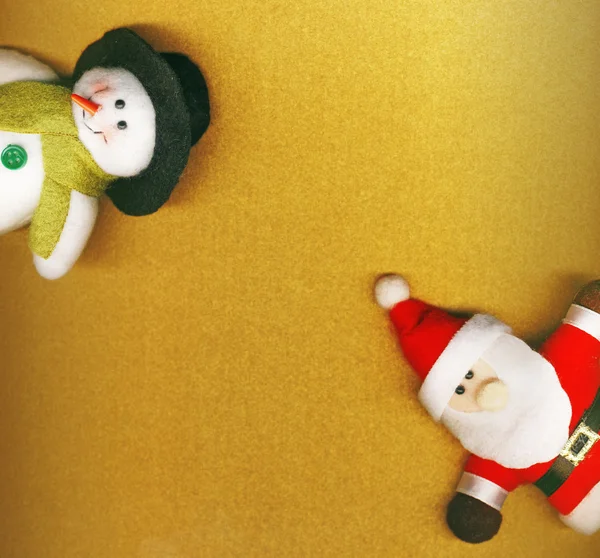 Santa Claus y muñeco de nieve en el fondo dorado de Navidad —  Fotos de Stock