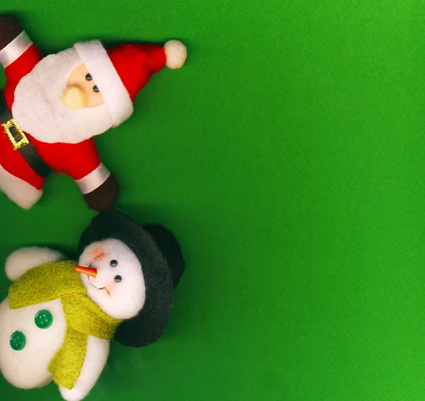 Santa Claus y muñeco de nieve en el fondo verde —  Fotos de Stock