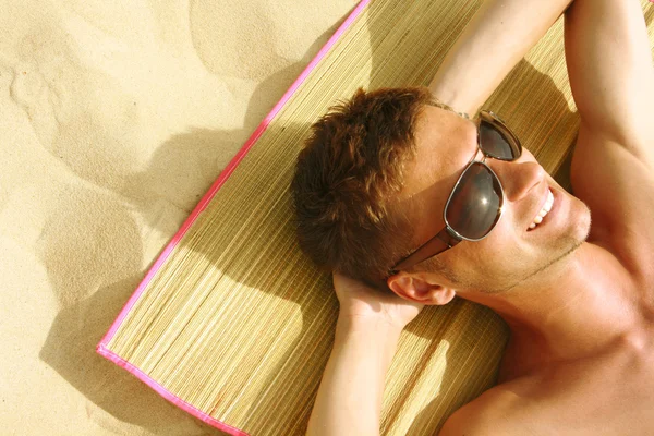 Hombre tomando el sol en la playa — Foto de Stock