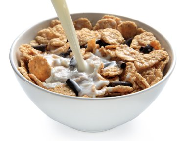 Milk poured into bowl of bran cereal clipart