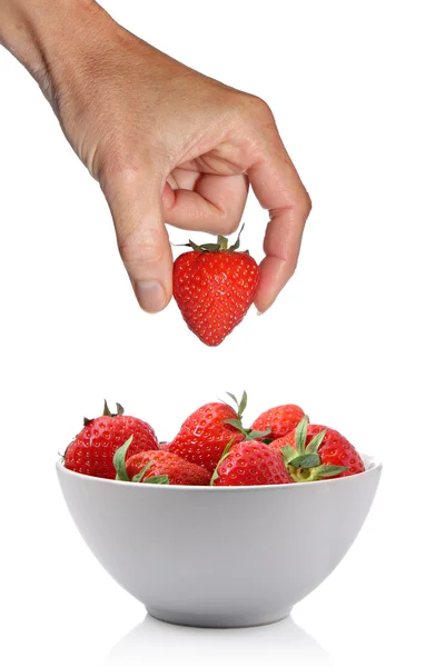 Hand taking strawberry out of bowl — Stock Photo, Image