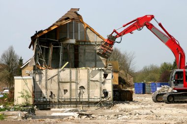 Excavator demolishing a building clipart