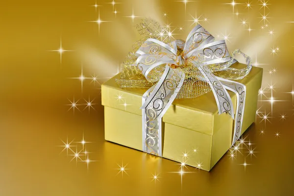 Gyllene presentförpackning eller presentera med band och rosett — Stockfoto