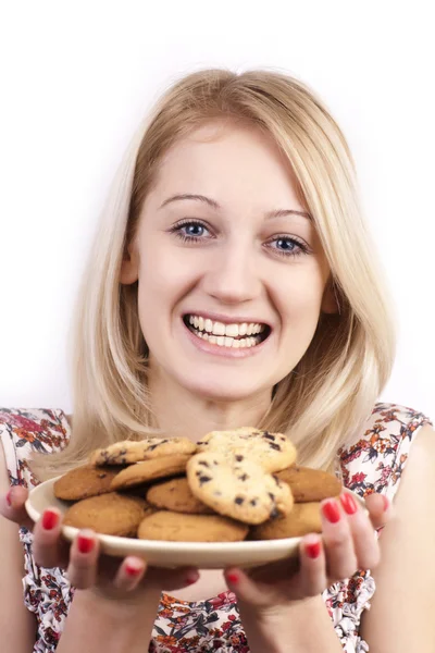 Young grimacing woman with plate of cookies isolated — Stock Photo, Image