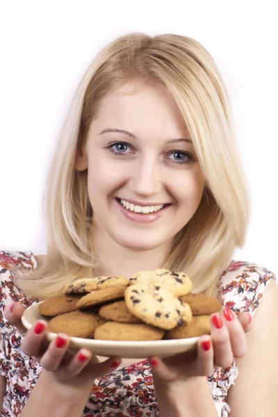 Молодая улыбающаяся женщина с тарелкой печенья — стоковое фото