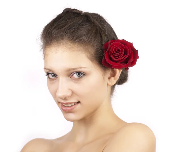 Portrait of young attractive woman with red flower in hair — Stock Photo, Image