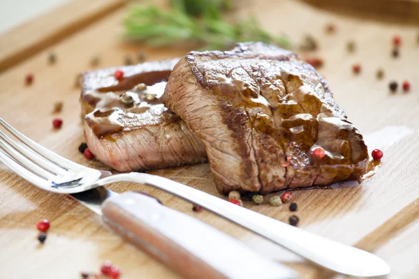 Twee steaks op een houten bord — Stockfoto