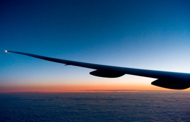 View of sunset from airplane wing clipart
