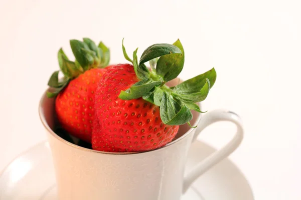 Fresas rojas frescas dentro de la taza de té blanca — Foto de Stock