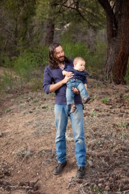 Father and son having fun in the forest clipart