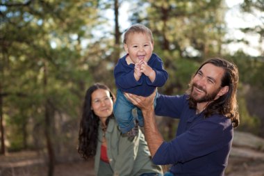 Young family having fun in nature clipart