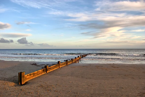 stock image Wooden Wave Breaker on the Sandy Beach