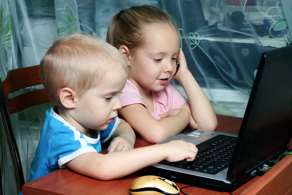 Niño y niña trabajando juntos en un ordenador portátil — Foto de Stock