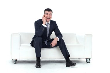 genç adam WHI izole bir kanepede oturuyor telefonda konuşurken