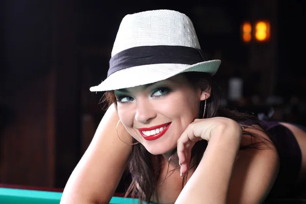 Портрет сексуальной девушки в белой шляпе, лежащей на столе для — стоковое фото