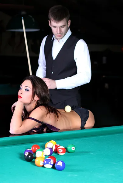 Білий м'яч лежить на голій спині дівчини і чоловік дивиться на Ліцензійні Стокові Фото