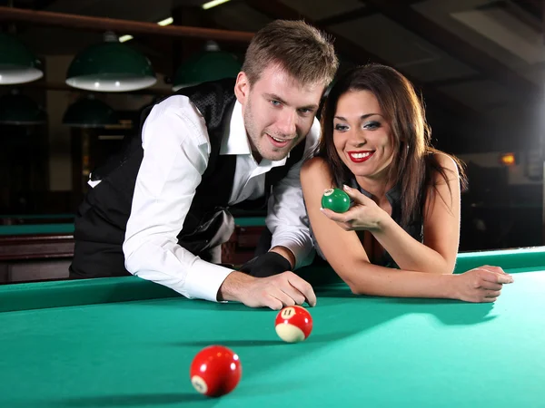 Retrato de um casal jogando snooker em um clube escuro Imagens De Bancos De Imagens
