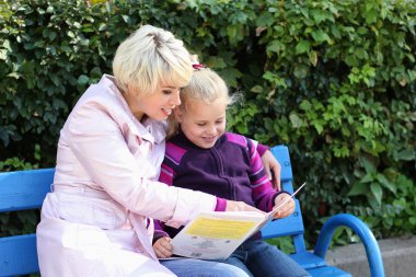 park ve rea bir bankta oturan bir kız olan bir genç kadın