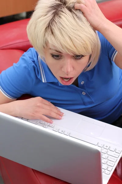 여자는 소파에 앉아서 노트북을 사용 하 여 — 스톡 사진