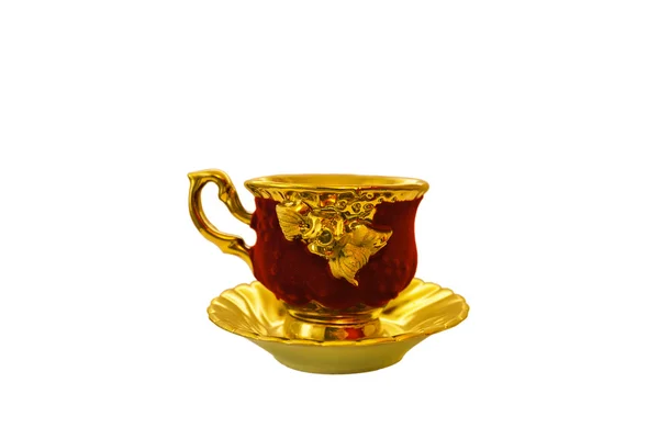 Золотая чашка с блюдцем — стоковое фото