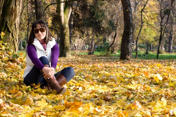 Chica en hojas de otoño — Foto de Stock