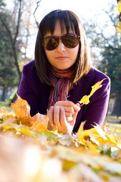 Chica en hojas de otoño — Foto de Stock