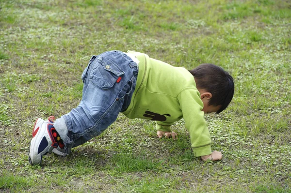 Bebê brincando no gramado — Fotografia de Stock