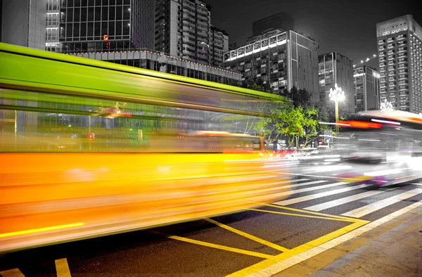 Rutas de luz de autobús borrosas y de alta velocidad en el paisaje nocturno del centro — Foto de Stock