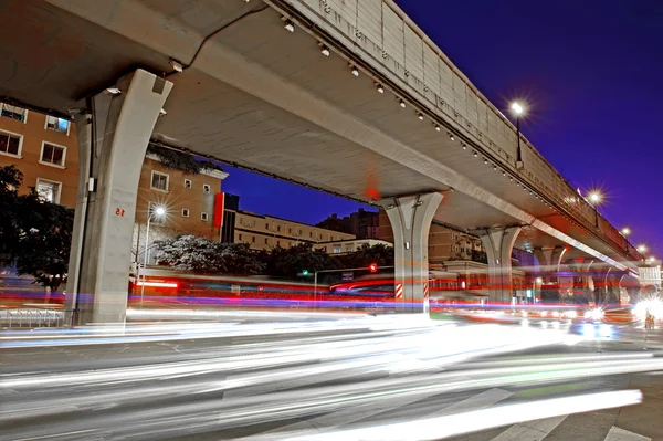 Высокоскоростное движение и размытые световые трассы под эстакадой — стоковое фото