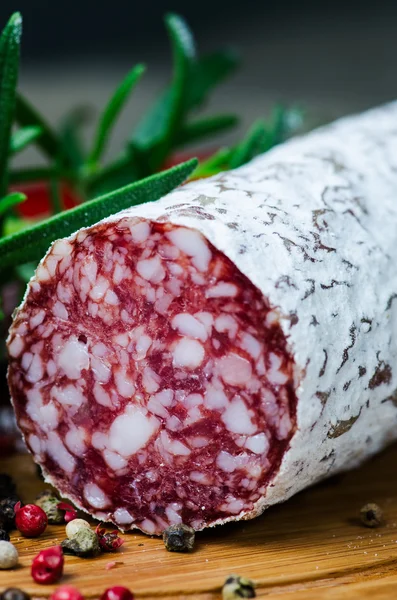 stock image Salami peper corns rosemary on cutting board