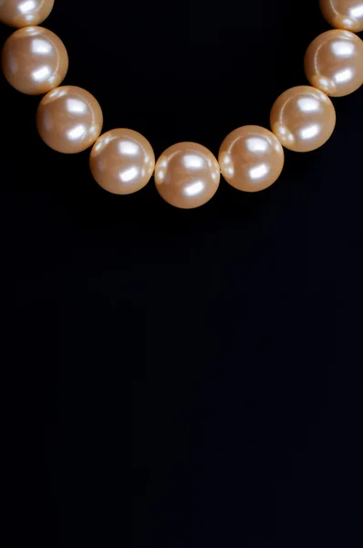 Beige necklace on a black background — Stock Photo, Image