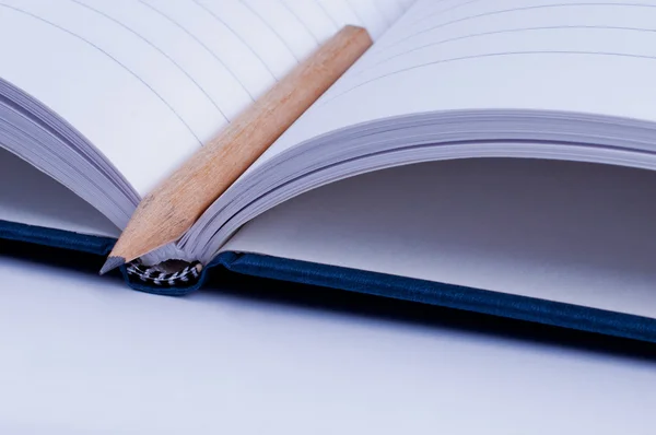 Cuaderno azul abierto con lápiz — Foto de Stock