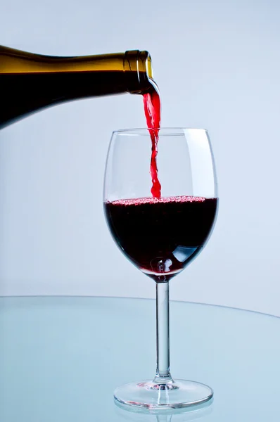 Vin rouge coulant de la bouteille — Photo