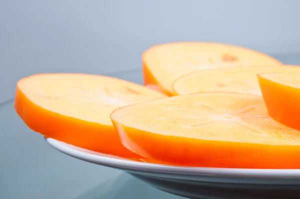 Cuted persimmon paar stukken op plaat — Stockfoto