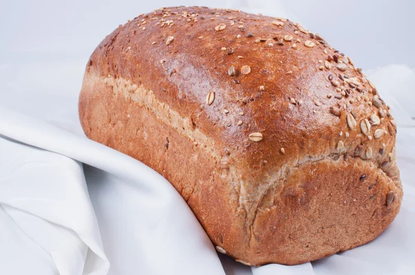 Буханка хлеба на белом льне — стоковое фото