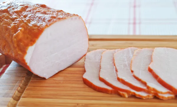 stock image Ham cut into slices on a wooden board