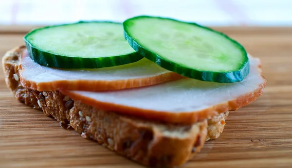 Smörgås med gurka och skinka på en planka — Stockfoto