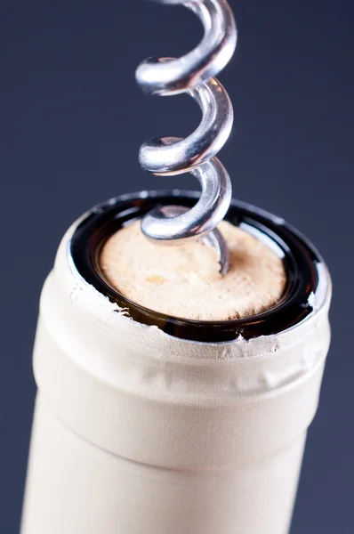 Corkscrew in cork in een fles wijn op de grijze achtergrond — Stockfoto