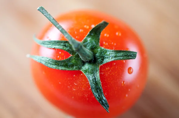 Los tomates rojos cereza en una tabla de cortar de cerca —  Fotos de Stock