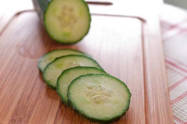 Sliced ​​cucumber on a wooden board close up — Stock Photo, Image