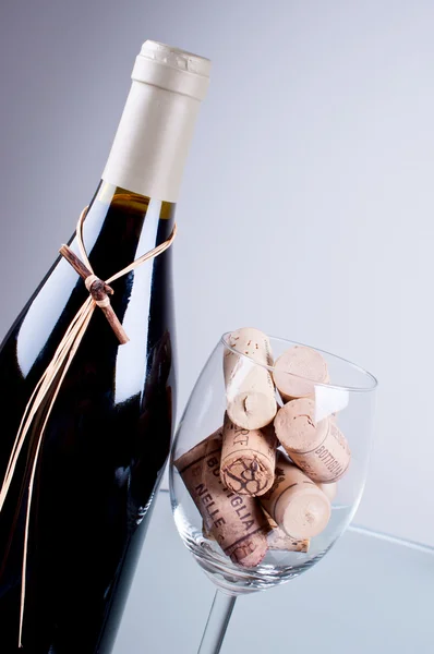 Garrafa de vinho e rolhas cheias de vidro — Fotografia de Stock