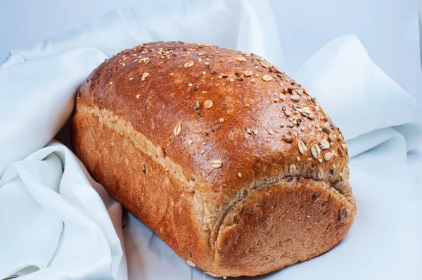 Stock image Loaf of bread on white satin fabric