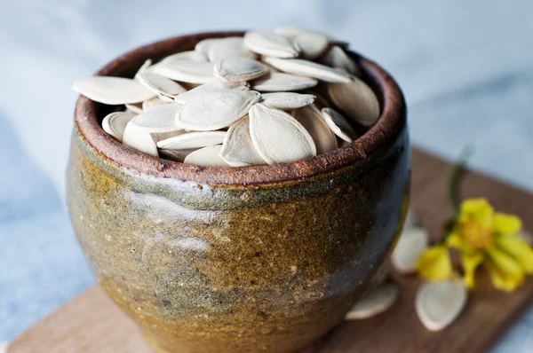 Keramik skål full av pumpafrön på köksbordet — Stockfoto
