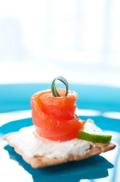 Canapes with smoked salmon on blue background — Stock Photo, Image