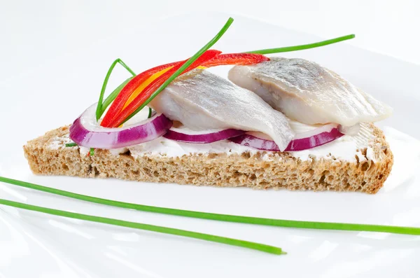 Ringa balığı sandviçi siyah ekmek üzerinde — Stok fotoğraf
