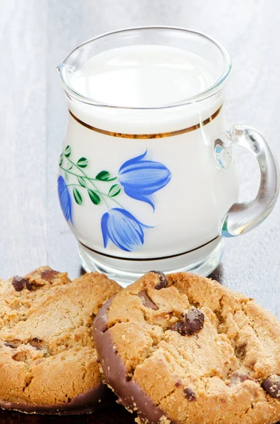 Сhocolate cookies and milk in jug — Stock Photo, Image