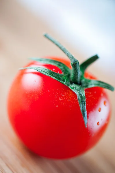 Red tomato on cutting board — Stock Photo, Image