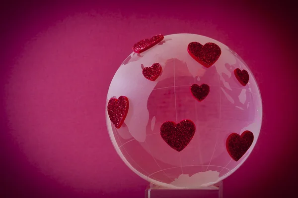 De planeet van de liefde. glazen bol met rode harten. — Stockfoto