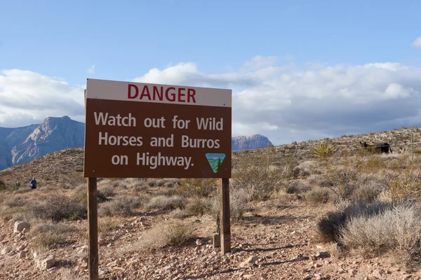 Stock image Sign warning of wild horses and burros on highway.